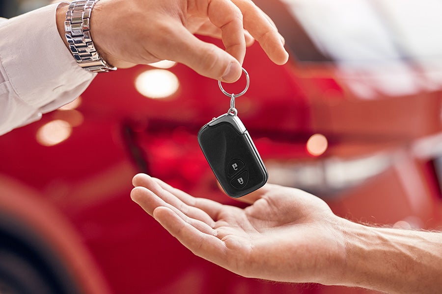 Car keys being passed between hands